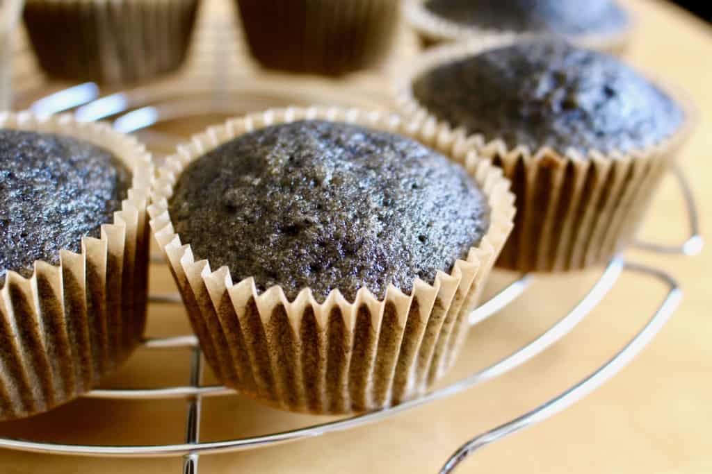 Black cupcakes baked and cooling, waiting to be frosted