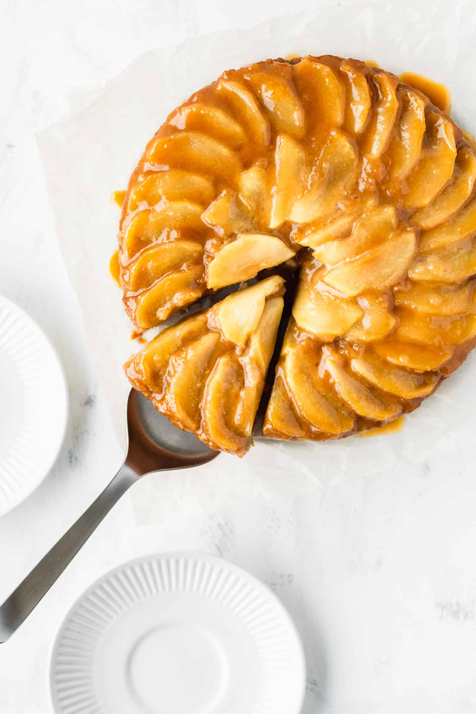 Vegan apple upside-down cake with a slice cut out.
