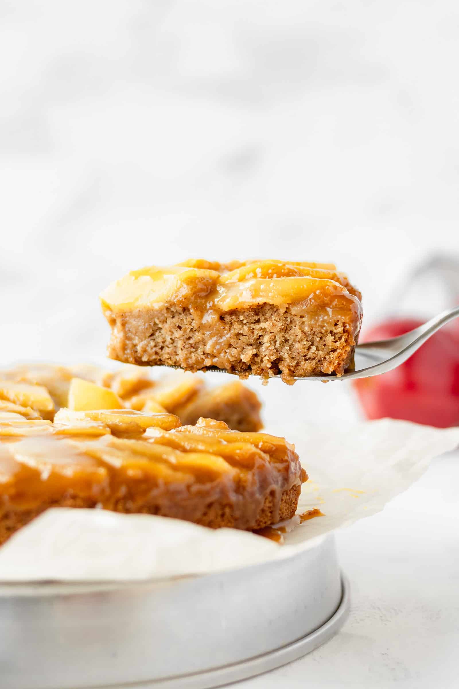 A slice of vegan apple cake being lifted up.