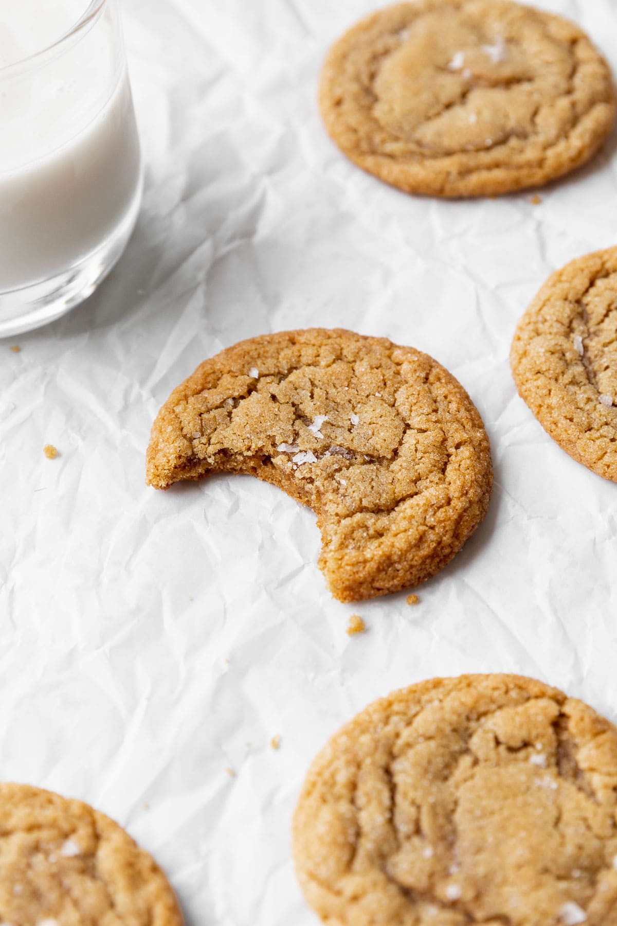 A closeup of a dairy-free peanut butter cookie with a bite taken out of it.