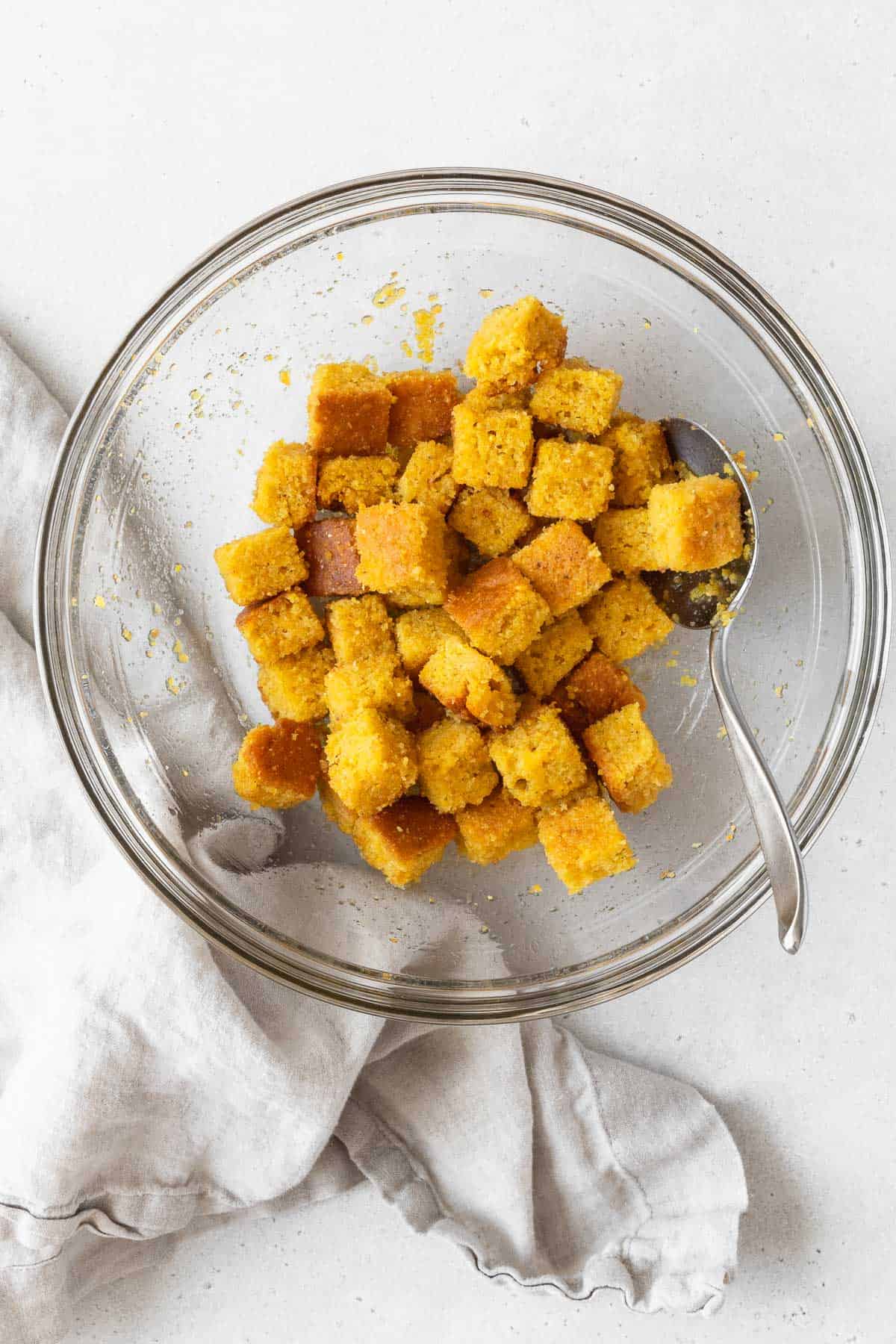 A large mixing bowl of the corn bread croutons before baking.