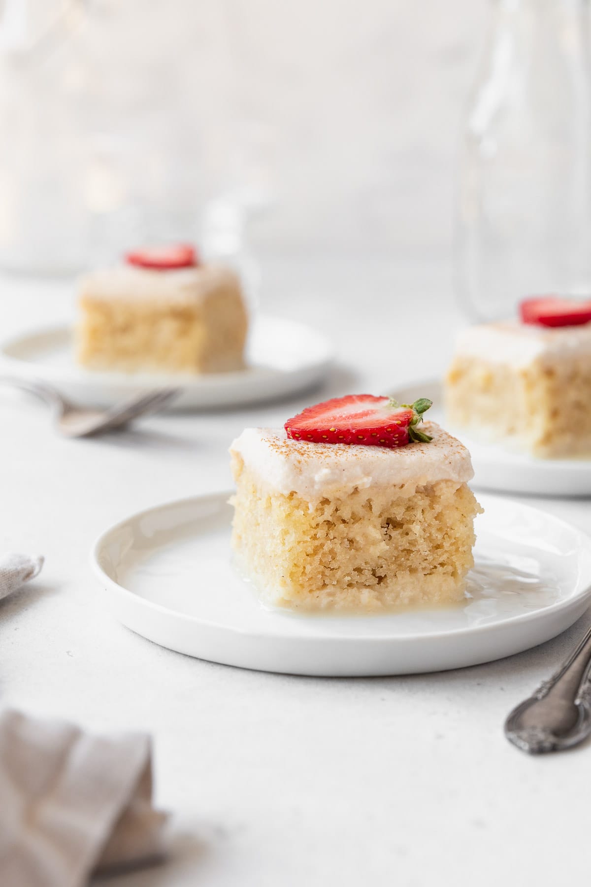 A closeup side shot of a slice of gluten-free and dairy-free tres leches cake on a dessert plate.